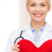 A female doctor holding a heart with a stethoscope while discussing seasonal hair loss.