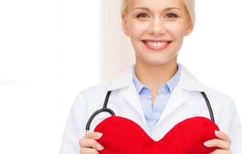 A female doctor holding a heart with a stethoscope while discussing seasonal hair loss.