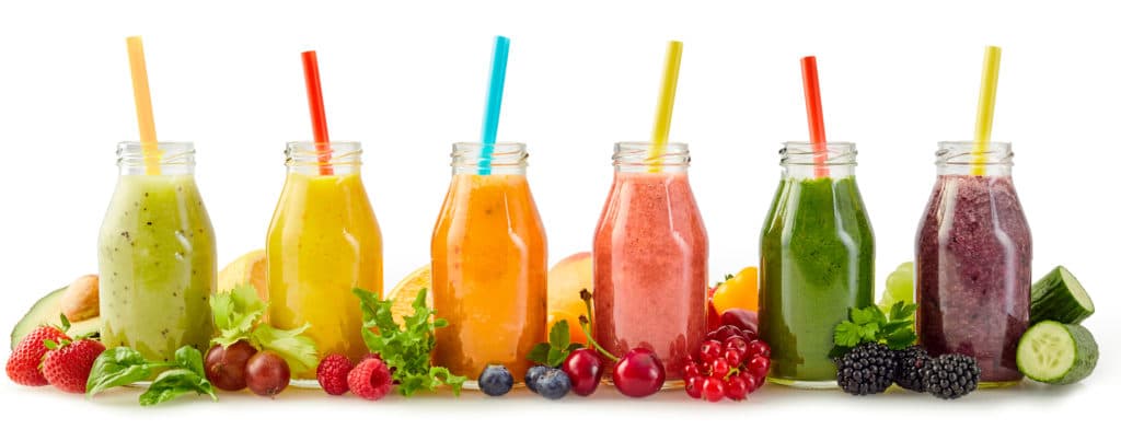 A row of healthy fresh fruit smoothies for hair nutritional needs