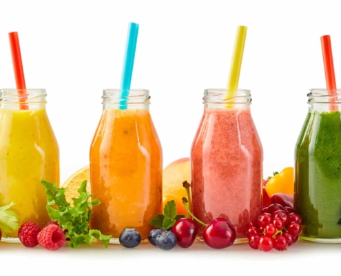 A row of healthy fresh fruit smoothies for hair nutritional needs