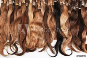 A bunch of hair extensions on a white background, displaying options for hair loss treatment and hair thinning.