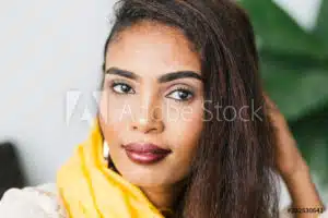 Portrait of beautiful African woman with alopecia wearing a yellow scarf.