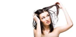 A woman with trichotillomania is combing her hair on a white background.