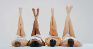 Women holding up their legs for laser hair removal appointment