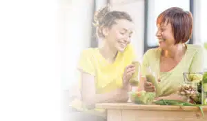 Two women sitting at a table and enjoying hormone-balancing smoothies.