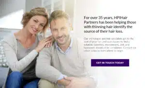 A man and woman are sitting on a couch, discussing hair loss and treatment options for their hair thinning.