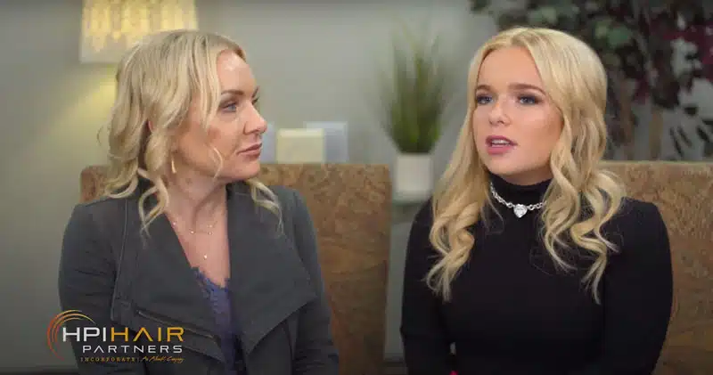 Two women sitting next to each other on a couch, discussing hair restoration and customized treatment plan journey