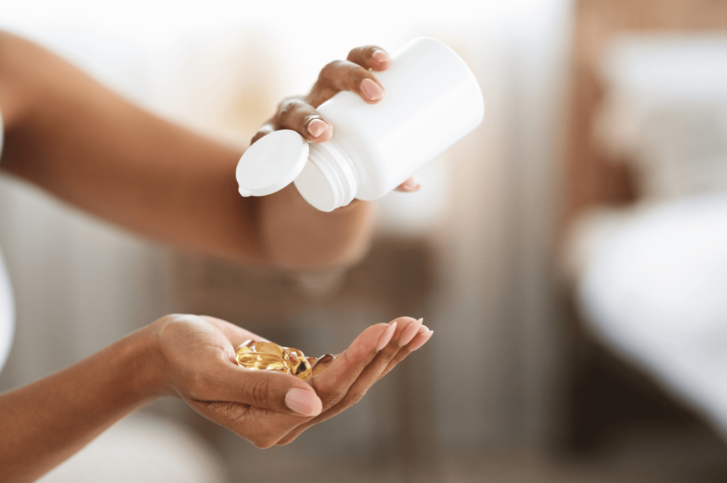 A female pouring out hair vitamins from a white bottle