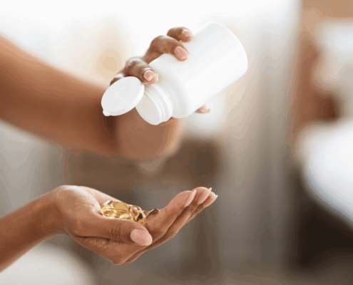 A female pouring out hair vitamins from a white bottle