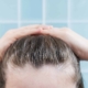 A woman is naturally styling her hair with her hands.