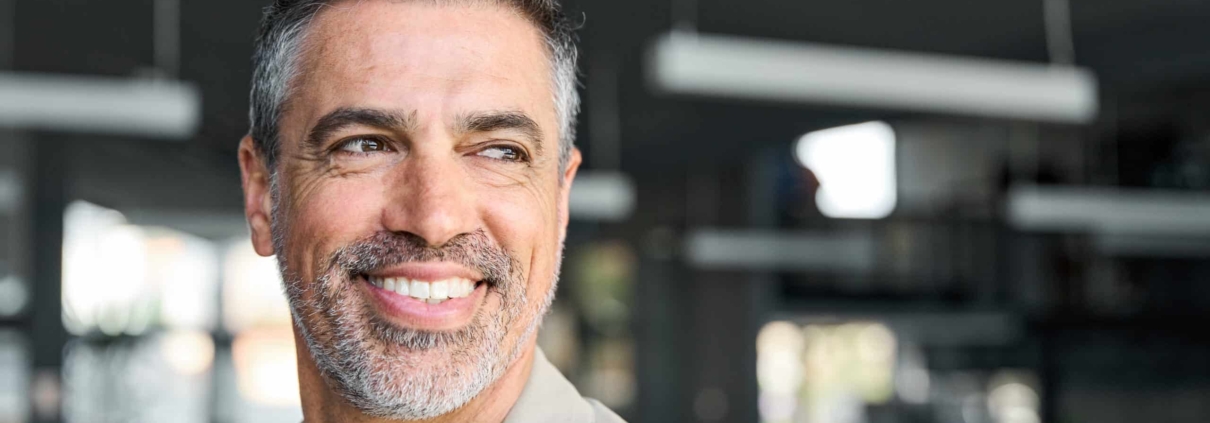 A man with a beard and mustache, exuding confidence and happiness.