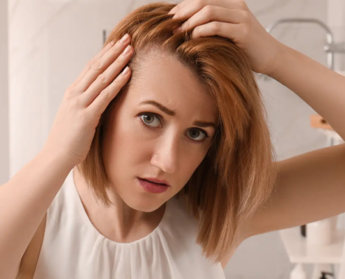 Woman looking in the mirror, gently touching her hair, conveying emotion and reflection